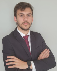 Um homem em close, estudante de direito e estagiário, usando terno, Daniel Almeida Pires